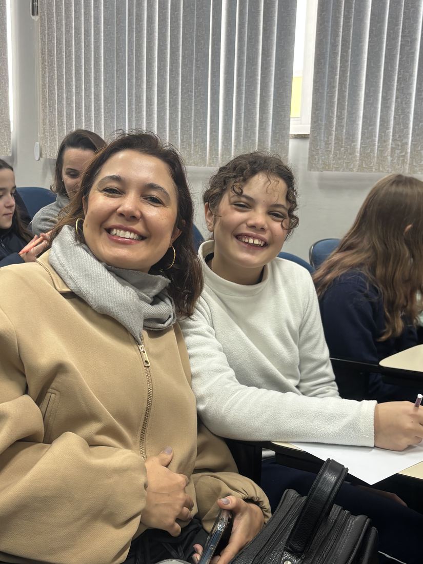 Mãe e filha sorrindo juntas no colégio