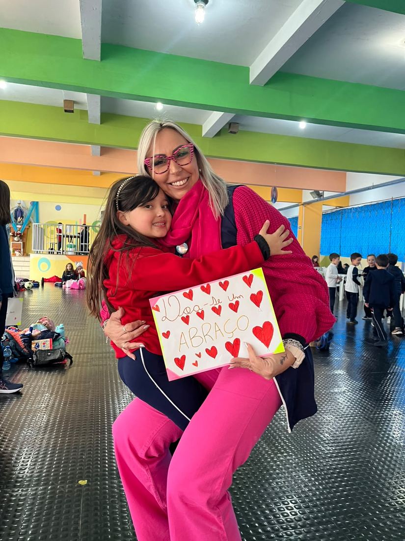 Aluna mostrando cartaz de coração feito em atividade socioemocional